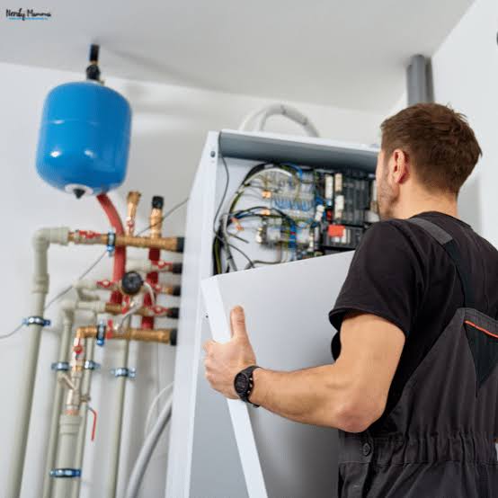 Heating technician inspecting an open residential mechanical system