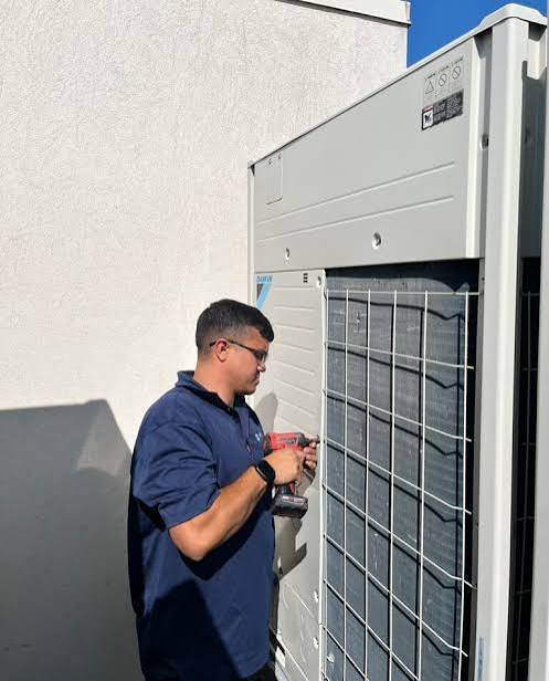 HVAC technician working on a large outdoor cooling unit
